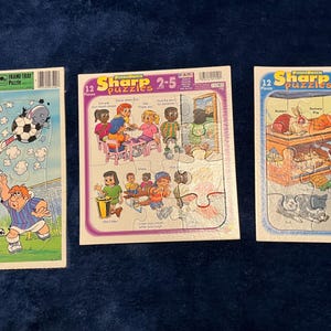 May include: Three children's jigsaw puzzles. One features Goofy playing soccer, another shows children at a table, and the third depicts animals. Each puzzle has 12 pieces and is designed for ages 2-5.