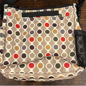 Puede incluir: Bolso de hombro beige con un patr&oacute;n repetitivo de c&iacute;rculos conectados en rojo, marr&oacute;n, gris y amarillo. El bolso tiene una correa negra, un bolsillo lateral de malla y un peque&ntilde;o bolsillo lateral.