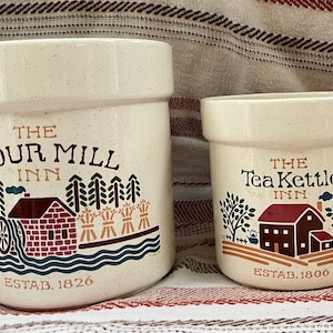Puede incluir: Dos botes de cer&aacute;mica con un tema de casa de campo. El bote m&aacute;s grande es blanco con motas marrones y dice "The Flour Mill Inn Est. 1826". El bote m&aacute;s peque&ntilde;o es blanco con motas marrones y dice "The Tea Kettle Inn Est. 1800".
