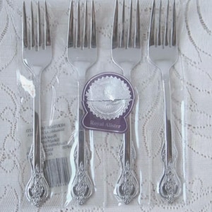 Può includere: Quattro forchette d'argento con manici decorati, confezionate singolarmente in plastica. La confezione include un'etichetta che recita "Royal Ailister" e "Heritage Collection".