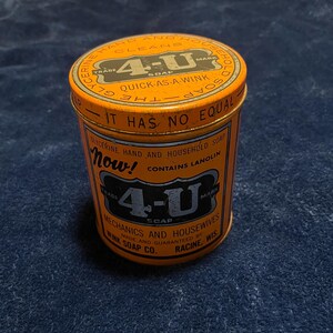 Puede incluir: Una lata de jabón 4-U vintage naranja con texto negro. La lata dice "Jabón de glicerina para manos y hogar" y "Quick as a Wink". La lata cilíndrica tiene tapa y presenta el texto "Mechanics and Housewives", fabricado en Racine, Wisconsin.