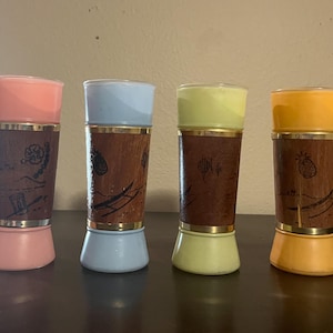 Puede incluir: Cuatro saleros y pimenteros vintage con un diseño moderno de mediados de siglo. Cada coctelera tiene una parte superior e inferior de diferente color pastel, con un centro de madera con diseños grabados. Bandas doradas acentúan la parte superior e inferior de la sección de madera.