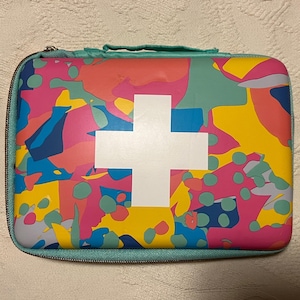 May include: A colorful first aid kit with a white cross on a teal background. The kit has a zipper closure and is made of a durable material.