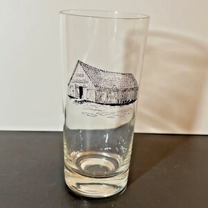 May include: A clear glass drinking glass with a black and white illustration of a barn with the text "1868 Distillery" on the side.