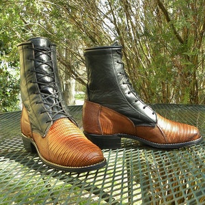 May include: A pair of two-tone leather boots. The upper portion is black, while the lower section and vamp feature a textured, brown reptile-like pattern. The boots have black laces and a low heel, suitable for various occasions.