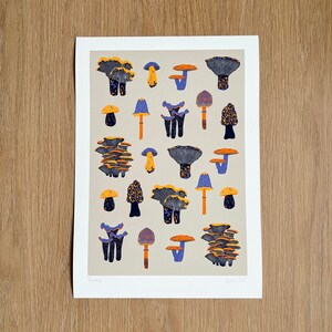 May include: A print of a collection of mushrooms in various shades of blue, purple, orange, and yellow on a beige background.