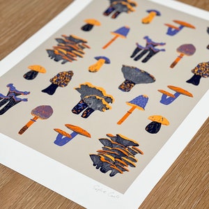 May include: A print of a collection of colorful mushrooms in various shapes and sizes. The mushrooms are illustrated in shades of orange, yellow, blue, and purple on a light gray background. The print is signed "Sophie Cooke".