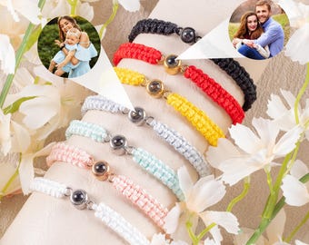 May include: A collection of colorful woven bracelets with magnetic clasps. The bracelets are in various colors, including red, yellow, black, and white. Each bracelet features a small, round charm. The image also includes two circular photos.