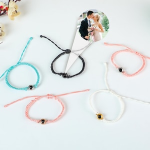 Puede incluir: Cinco pulseras de amistad de colores con un peque&ntilde;o dije redondo en el centro. Los dijes son negros, dorados y plateados. Las pulseras est&aacute;n hechas de un hilo delgado y est&aacute;n atadas con un nudo.