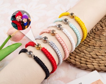 May include: A set of eight colorful friendship bracelets with a small, round, clear glass charm. Each bracelet is made of a braided cord and has a silver metal clasp.