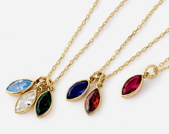 May include: Three gold necklaces with different colored gemstone pendants. The pendants are marquise shaped and feature blue, green, and red gemstones.
