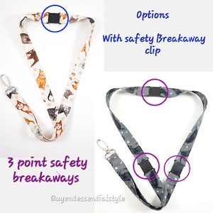 May include: Two lanyards with safety breakaway clips. The first lanyard is white with a cat print and has a single breakaway clip. The second lanyard is grey with a star print and has three breakaway clips. The text "Options" and "With safety Breakaway clip" is visible in the image. The text "3 point safety breakaways" is visible in the image. The text "@uyeritessentialsstyle" is visible in the image.