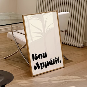 May include: A framed print with a white background and a black silhouette of trees. The text "Bon Appétit." is printed in bold black letters at the bottom of the print.