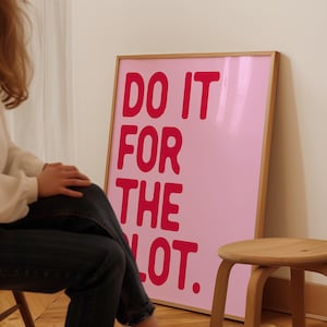 Puede incluir: Un póster enmarcado en rosa con el texto "DO IT FOR THE PLOT." en letras rojas y negritas.