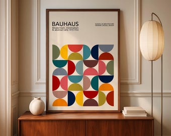 May include: A framed Bauhaus art print featuring a colorful geometric design of semi-circles in various colors. The print includes the text "BAUHAUS" and "Modernism, minimalism & abstract arts 1919-1933". The print is displayed on a wooden cabinet.