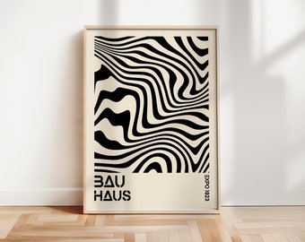 Peut inclure: Une impression abstraite en noir et blanc avec des lignes ondulées. L'impression est encadrée dans un cadre en bois clair et porte le texte "BAUHAUS" et "EXPO 1923" en bas.