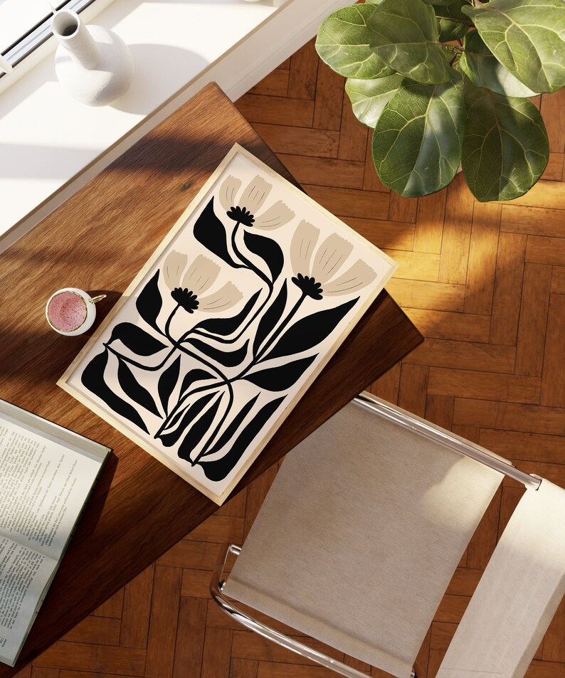 May include: A framed print with a minimalist design featuring stylized black leaves and beige flowers on a cream background.