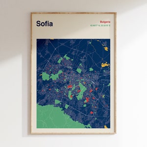 Puede incluir: Una impresión enmarcada de un mapa de Sofía, Bulgaria. El mapa presenta un fondo azul oscuro con detalles verdes, rojos y amarillos. La palabra "Sofia" está impresa en negro en la parte superior, con "Bulgaria" y coordenadas en rojo y verde.