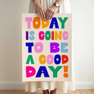 May include: A rectangular poster with the phrase "TODAY IS GOING TO BE A GOOD DAY!" in large, colorful, block letters. The letters are in shades of pink, orange, blue, green, and purple against a cream background.