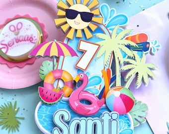 Op de afbeelding: Kleurrijke taarttopper met een zomerthema. Het toont een lachende zon met zonnebril, een flamingo-drijver, een strandbal en de naam "Santi". Andere elementen zijn het cijfer 7, een watermeloen en een parasol.