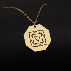 May include: Gold necklace with a pendant featuring a geometric design representing the sacral chakra, a symbol of creativity and emotions.