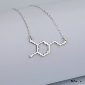 Add a spark of science and style to your look with this elegant Sterling Silver Dopamine Necklace. Featuring a detailed dopamine molecule design, this necklace is perfect for science lovers, students, teachers, or anyone who appreciates the chemistry of motivation and happiness. Crafted in high-quality sterling silver, it makes a meaningful gift for graduation, birthdays, anniversaries, or just because.