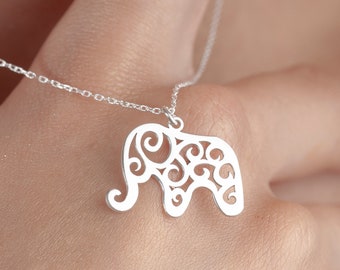 May include: A silver necklace with a delicate, filigree elephant pendant. The elephant is intricately designed with swirling patterns and a cutout shape.