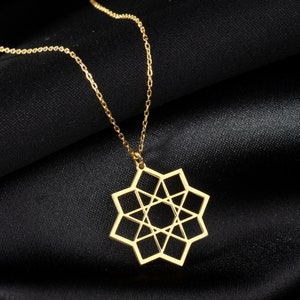 May include: A gold chain necklace with a geometric star pendant. The star is made of thin metal and has a detailed design.