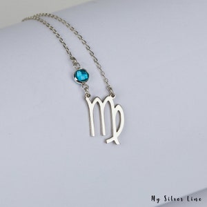 May include: Silver necklace with a Virgo zodiac symbol charm and a blue gemstone. The necklace is on a white background.