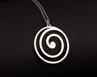 May include: A silver necklace with a circular pendant featuring a double spiral design. The pendant is made of polished silver and hangs from a delicate silver chain.