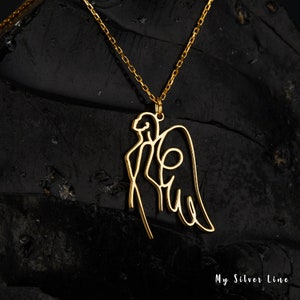 May include: Gold necklace with a delicate angel pendant. The pendant is a single line drawing of an angel with wings.