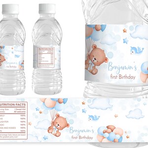 May include: Water bottle labels with a blue, white, and brown color scheme. The labels feature a cartoon bear holding balloons, clouds, and stars. The text on the label reads "Benjamin's first Birthday".