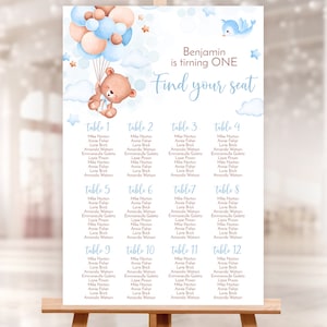 May include: A blue and brown baby shower seating chart with a teddy bear holding balloons. The chart is titled "Benjamin is turning ONE Find your seat" and lists the names of guests at each table.