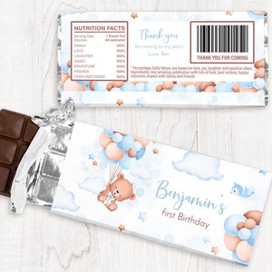 May include: A blue and brown chocolate bar wrapper with a cartoon bear holding balloons. The wrapper has the text "Benjamin's first Birthday" and a thank you message.