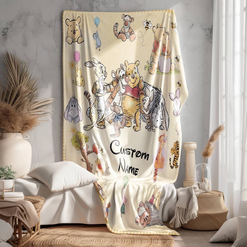 May include: A light yellow blanket featuring illustrations of Winnie the Pooh and friends. The blanket has a repeating pattern of characters and the text "Custom Name". The blanket is draped over a bed.