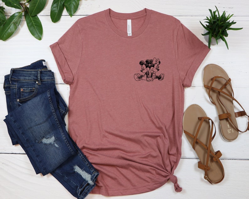 May include: A mauve t-shirt with a black and white image of Mickey Mouse and Minnie Mouse on the front.