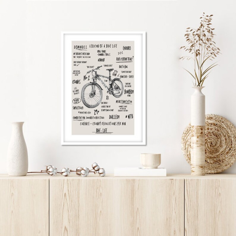 May include: A black and white illustration of a mountain bike with various terms related to mountain biking, such as "downhill", "enduro", "cranks", "bombing", and "dialled".