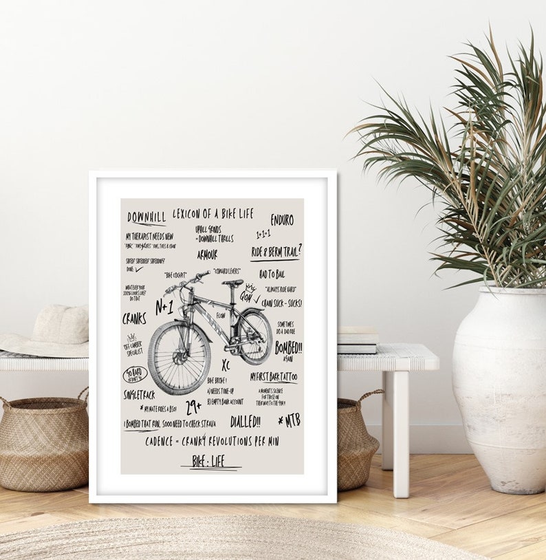 May include: A black and white illustration of a mountain bike with text describing the lexicon of a downhill bike life. The text includes terms like "Enduro", "Ride a Berm Trail", "Bombed", "Dialled", and "Cadence - Cranky Revolutions Per Min".