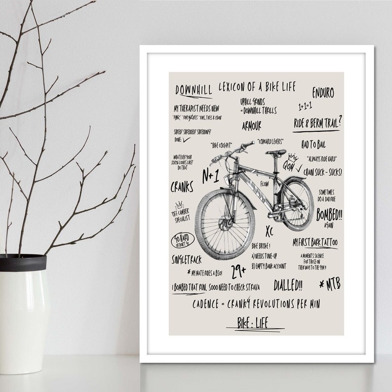 May include: Black and white illustration of a mountain bike with text describing the lexicon of a bike life. The text includes terms like 'Downhill', 'Enduro', 'XC', 'Single Track', 'N+1', 'Crank', 'Bombed', 'Dialled', 'Cadence', 'Bike Life', 'Ride & Berm Trail', 'Had to Bail', 'My First Bark Tattoo'.