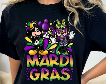 Könnte beinhalten: Schwarzes T-Shirt mit einem Motiv von Mickey Mouse und Minnie Mouse in Mardi Gras-Kostümen. Der Text "Mardi Gras" ist in Grün, Gelb und Lila unter den Figuren geschrieben.