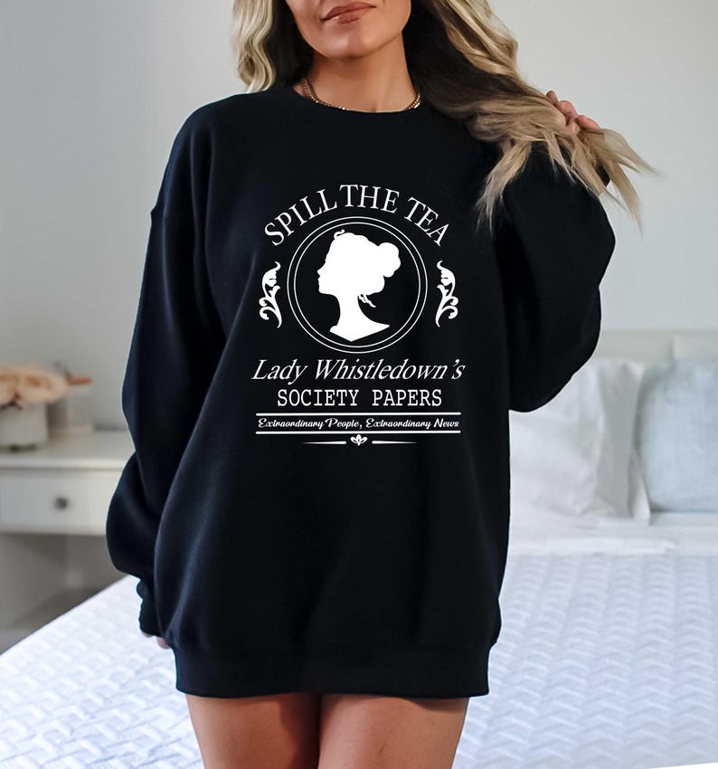 May include: Black sweatshirt with white text that reads "Spill the Tea" above a silhouette and "Lady Whistledown's Society Papers". The sweatshirt is a crew neck style.