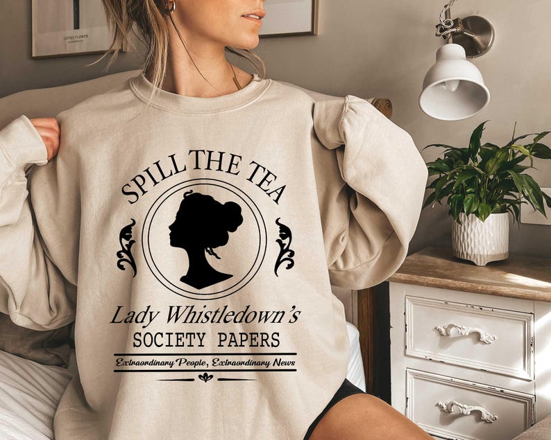 May include: Beige sweatshirt with the text "Spill the Tea" above a black silhouette of a woman's profile within a circle. Below, it reads "Lady Whistledown's Society Papers" and "Extraordinary People, Extraordinary News".