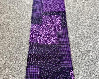 Tecido africano de algodão Ankara: estampa geométrica em patchwork roxa e preta para artesanato.