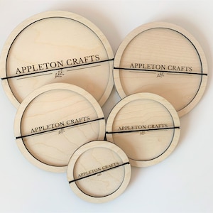Peut inclure: Ensemble de cinq cerceaux de bricolage ronds en bois de différentes tailles. Chaque cerceau porte l'inscription "APPLETON CRAFTS" et un motif de feuille, avec un élastique noir. Le bois est de couleur claire naturelle.