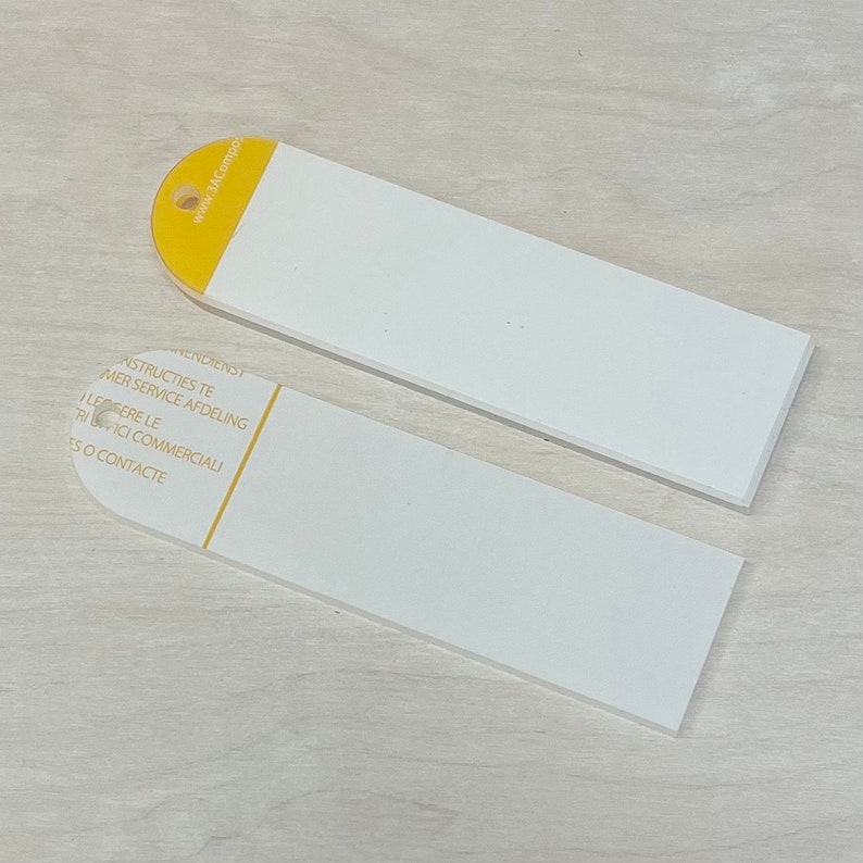 May include: Two white rectangular tags with rounded corners. The top tag has a yellow section with the text "www.3ACompagny.com". The bottom tag has the text "INSTRUCTIONS TE", "CUSTOMER SERVICE AFDELING", "LIGGERE LE", "FRICI COMMERCIAL", "ES O CONTACTE".