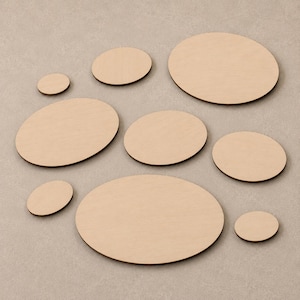 May include: A collection of eight smooth, light-coloured wooden ovals of varying sizes arranged in a scattered pattern. Each piece features a flat surface and a natural wood grain texture, presented as individual cutouts with rounded edges.