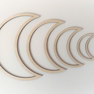 May include: Set of five wooden crescent moon shapes in various sizes, arranged in a row from largest to smallest.