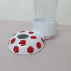 May include: White ceramic pet feeder with red polka dots and a clear glass jar for water or food.