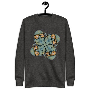 May include: A dark grey sweatshirt with a graphic print of four faces wearing sunglasses and smoking cigarettes. The faces are arranged in a circular pattern.