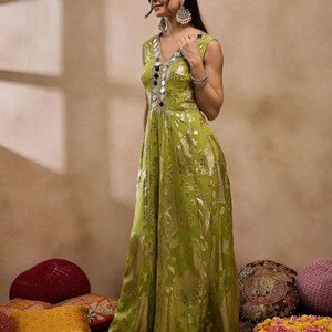 Op de afbeelding: Een groene maxi-jurk met paisley-patroon en zilveren spiegelversieringen. De jurk heeft een V-hals en is mouwloos.